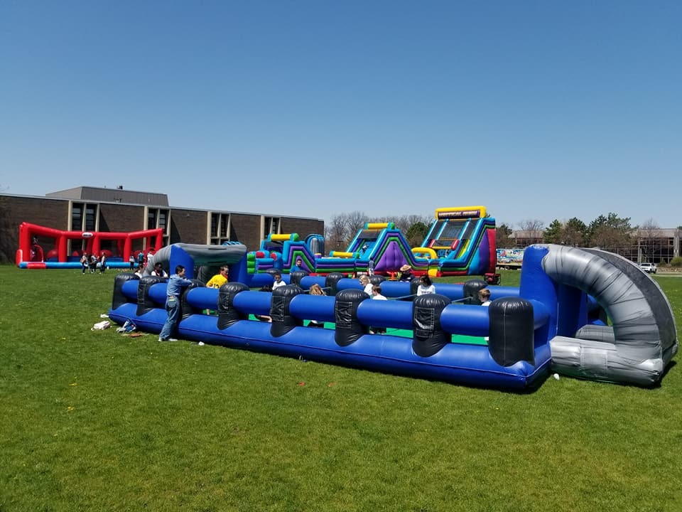 Human foosball and inflatable slides at outdoor school carnival Chicago