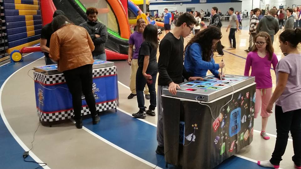 Carnival game booth rentals on basketball court at school event