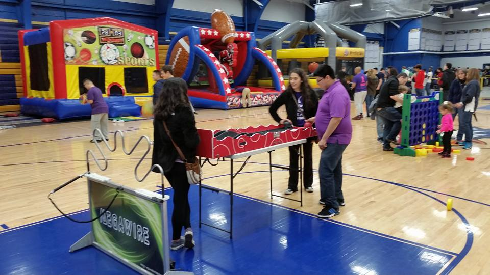 Full indoor school carnival setup in gymnasium for PTA fundraiser event in Chicago